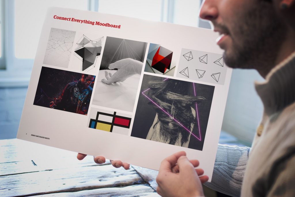 A designer holds up an Audinate audio advertising based moodboard