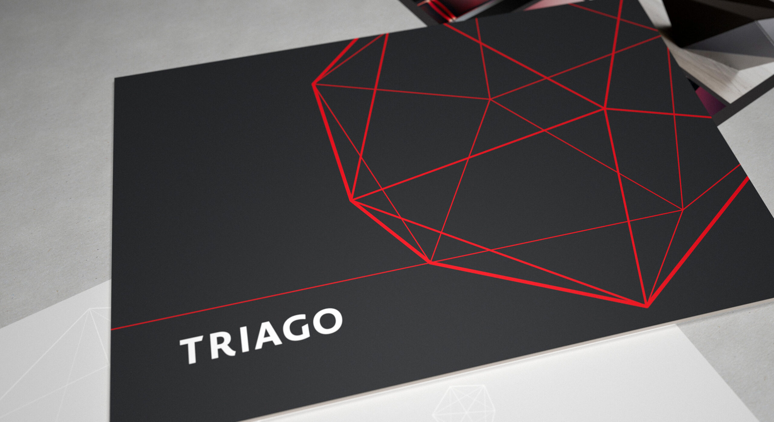 The Triago financial services brand identity uses a bold logotype, striking colour and a dodecahedra based supporting graphic device.